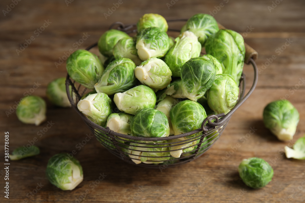 Metal basket with fresh Brussels sprouts on wooden table, closeup Metal basket with fresh Brussels sprouts on wooden table, closeup