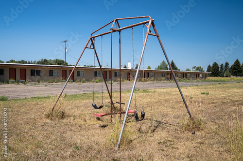 Bilde på lerret Rusty playground equipment with a swingset sits in a courtyard of an abandoned m
