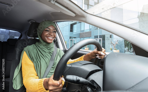 City Ride. Happy Smiling Black Muslim Lady In Headscarf Driving Modern Car