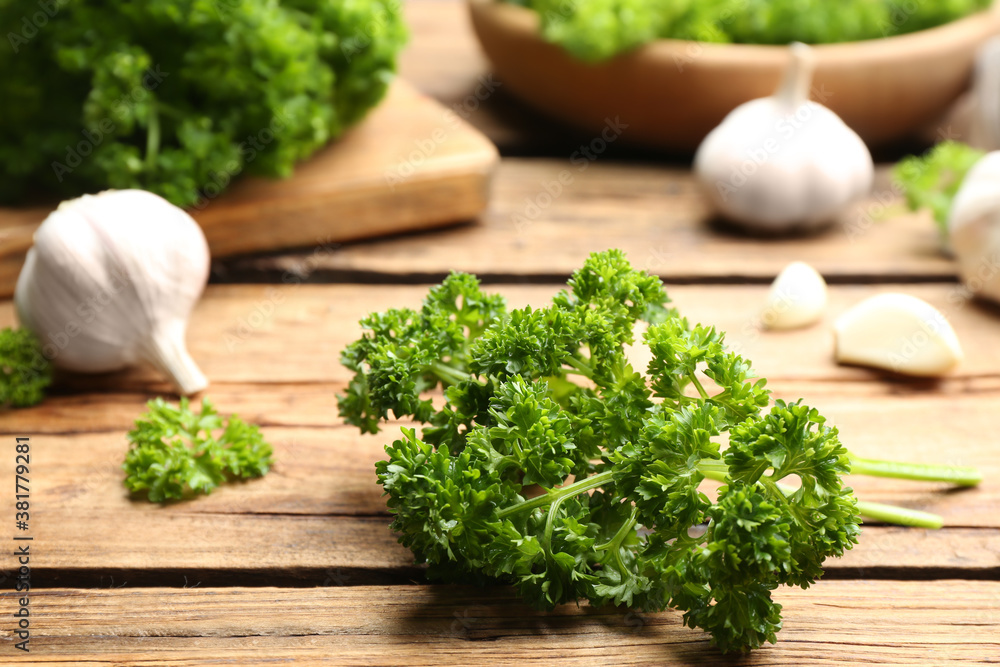 Fresh curly parsley and garlic on wooden table Fresh curly parsley and garlic on wooden table