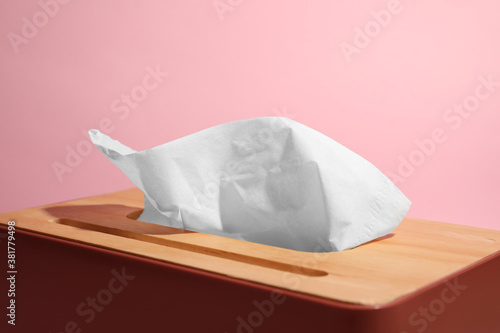 Holder with paper tissues on pink background  closeup