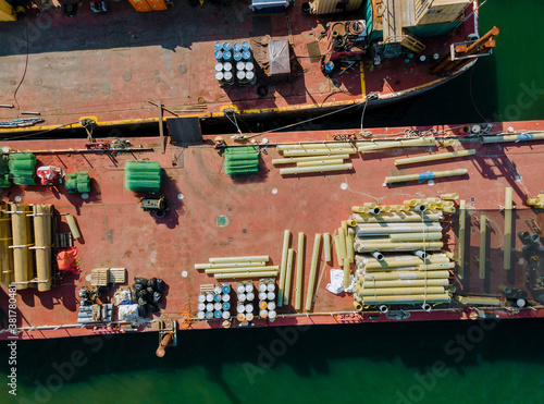 Cargo transportation by construction materials transportet building pipes and metal structures on barges © ungvar