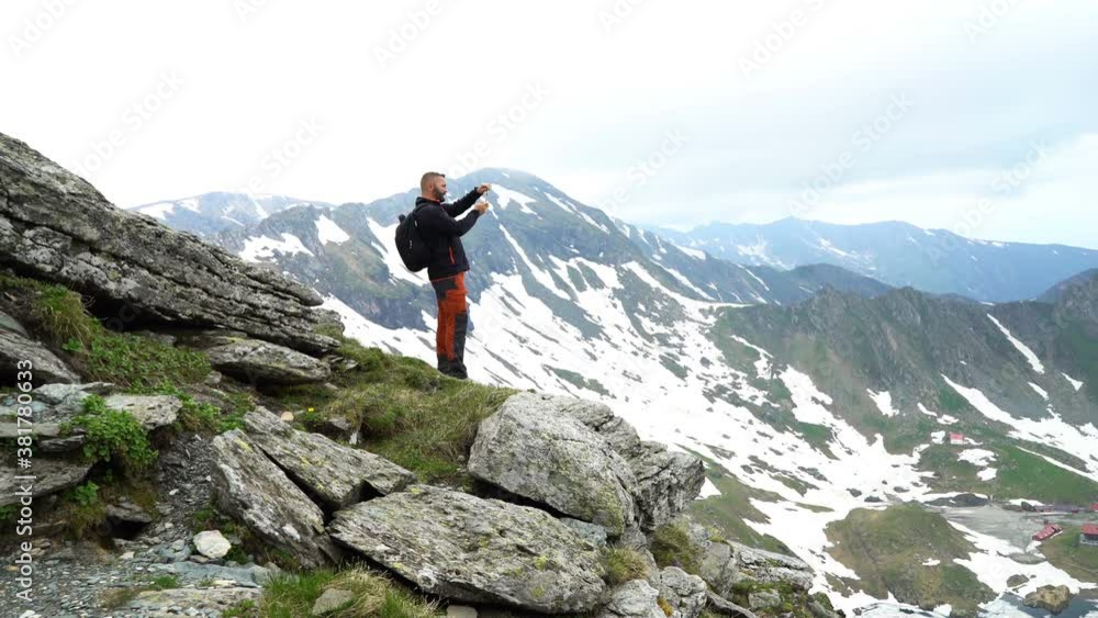 Young man taking photo with cellphone in the mountains Young man taking photo with cellphone in the mountains