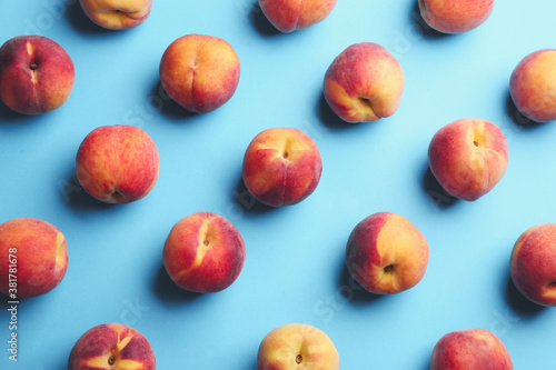 Fresh ripe peaches on light blue background, flat lay