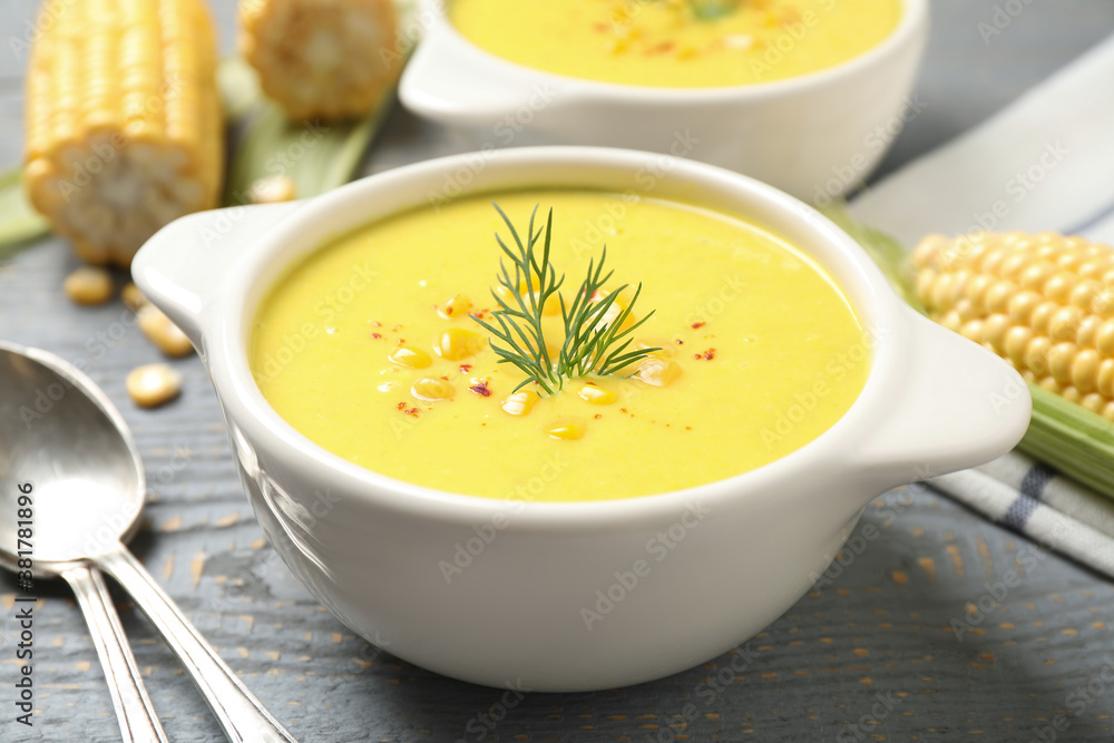 Delicious creamy corn soup served on grey wooden table Delicious creamy corn soup served on grey wooden table