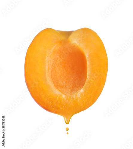 Apricot oil dripping from fresh fruit half on white background