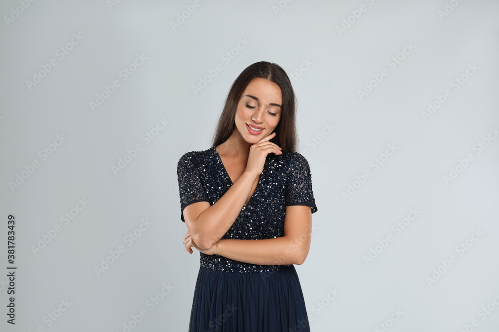 Young woman wearing stylish dress on light grey background Young woman wearing stylish dress on light grey background
