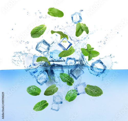 Ice cubes and green mint leaves falling into water on white background