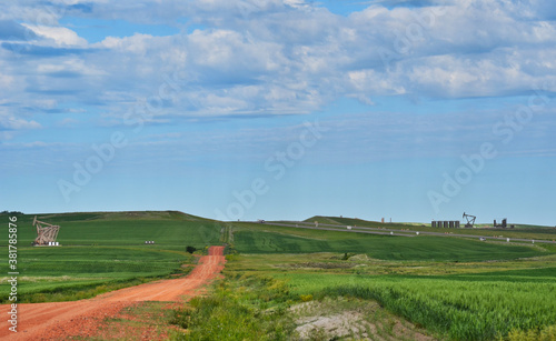 Fotografía Oil Pumps in Farm Fields along Road near Dickinson North Dakota on a Sunny Day