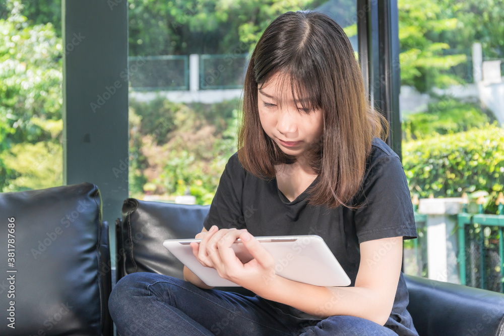 Young girl studying online from digital tablet in parlor Young girl studying online from digital tablet in parlor