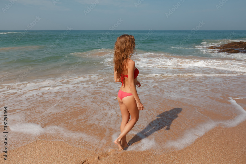 Woman walking away on the idylic beach, unrecognisable person Woman walking away on the idylic beach, unrecognisable person