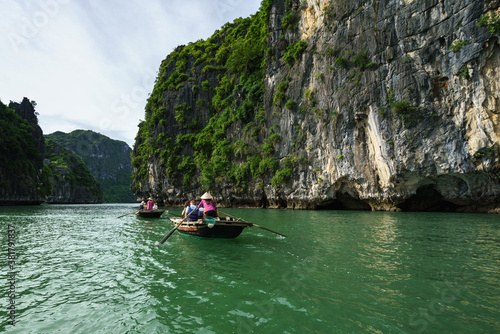 Halong bay in Vietnam, UNESCO World Heritage Site, with tourist rowing boats © Hanoi Photography