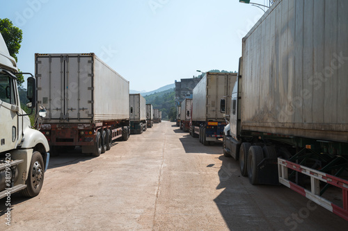 Heavy trucks loaded with goods trailers, parked in waiting area on state border crossing in Vietnam