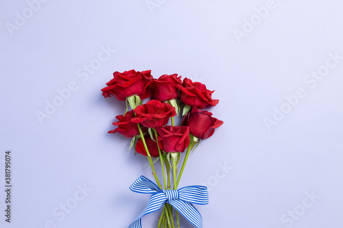 Red rose flowers bouquet on purple background. top view, copy space © Sanga