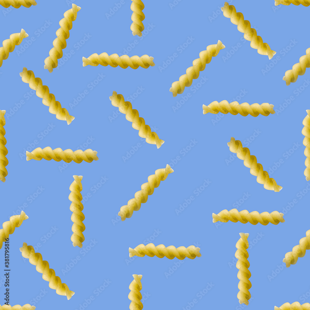 Obraz premium Fusilli pasta random flat lay on blue background without shadow. can be used as raw pasta background, poster, banner not pattern.
