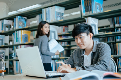 Students studying in the library with laptop at the university. Education concept.