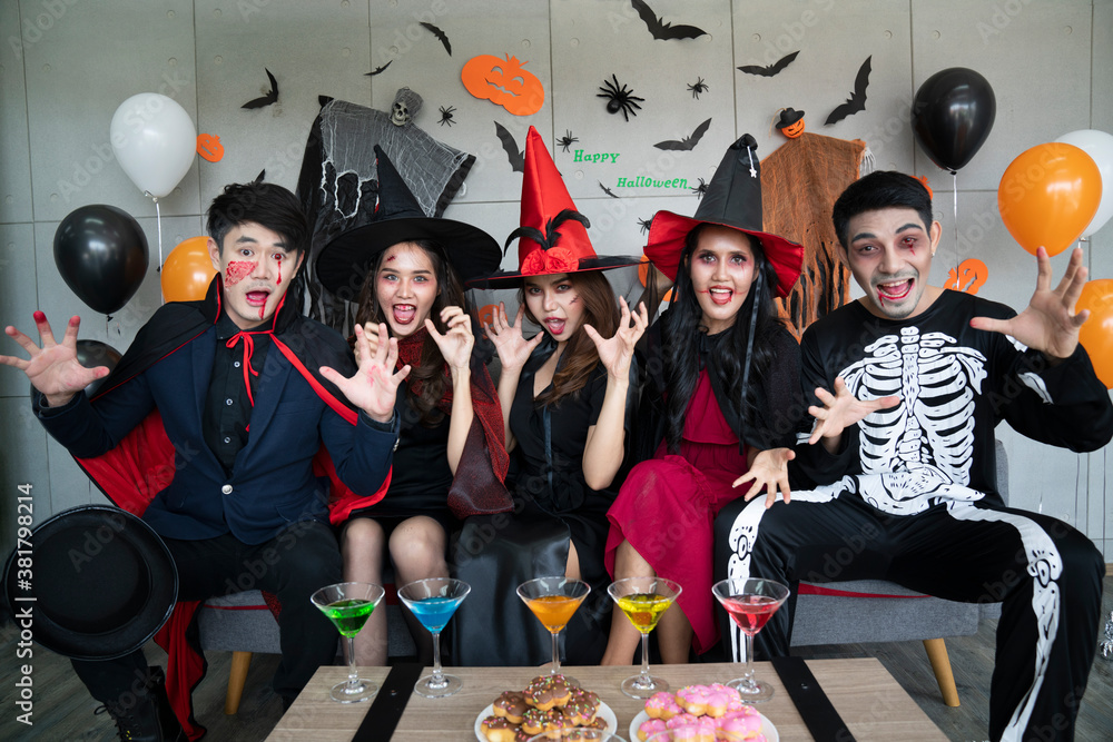 Fototapeta premium Young Asian people, a group of five people, in scary costumes. Group of friends wearing Halloween clothes preparing to join a party.