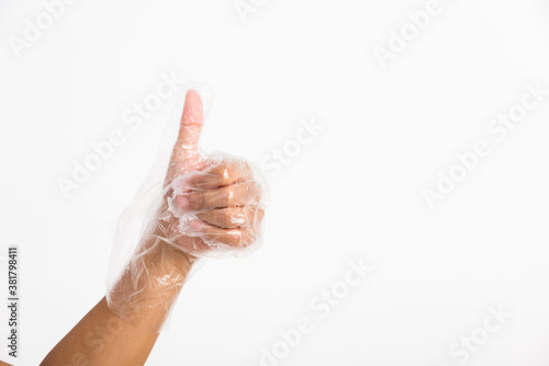 hand wearing disposable plastic glove with thumb up gesture
