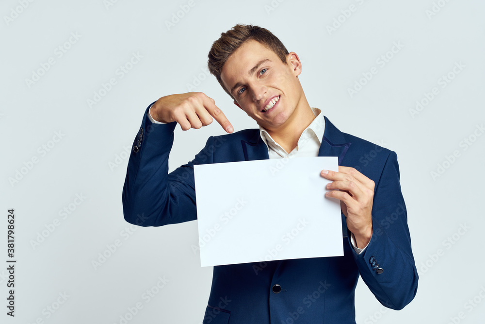A business man in a suit holds a paper in the hand of an official manager light background A business man in a suit holds a paper in the hand of an official manager light background