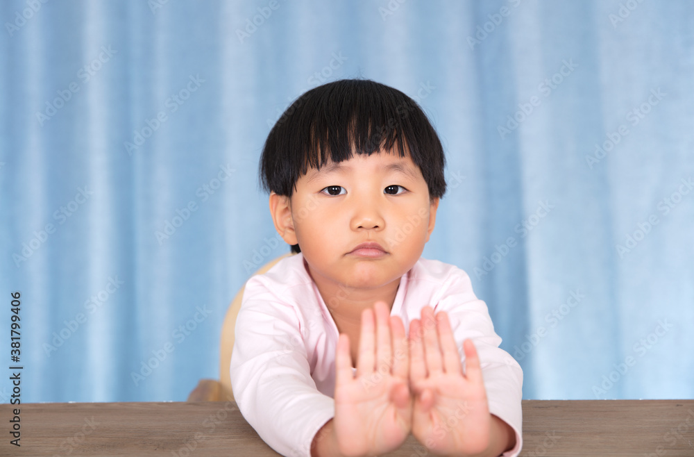 Cute little Chinese girl looking at the camera with both hands making rejection gesture Cute little Chinese girl looking at the camera with both hands making rejection gesture
