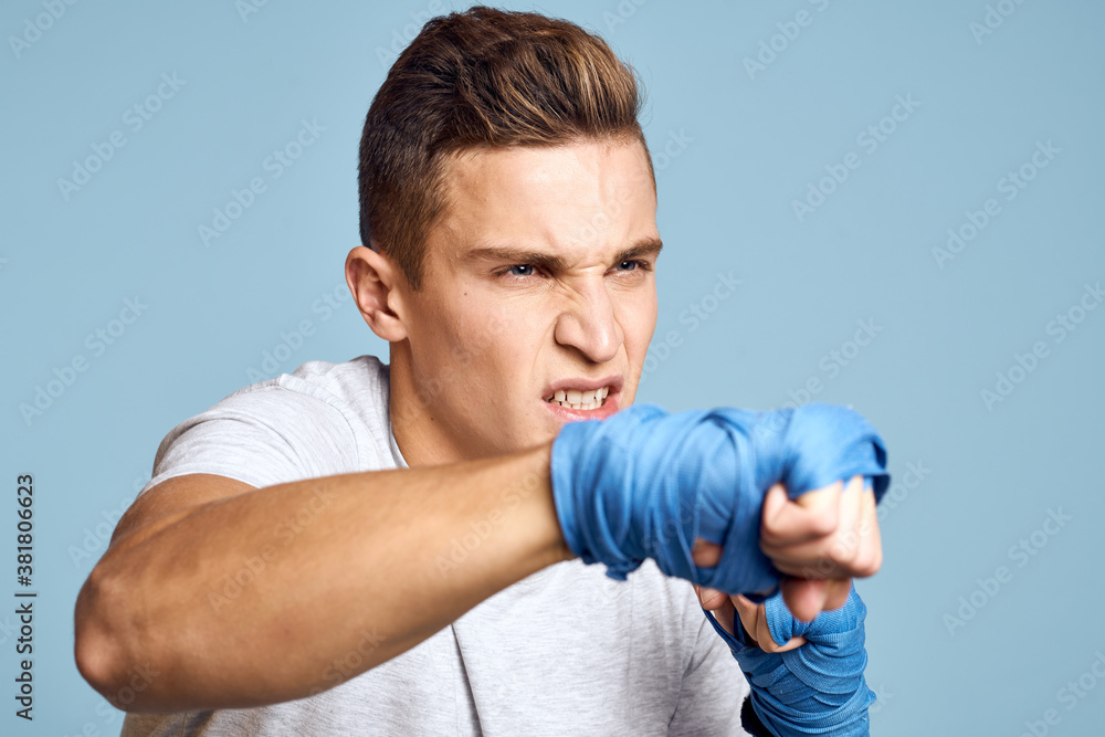 sporty man in blue boxing gloves and t-shirt on blue background practicing punches cropped view sporty man in blue boxing gloves and t-shirt on blue background practicing punches cropped view