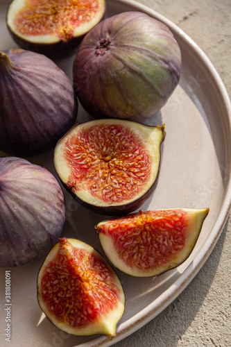 Fresh figs on a plate on a light concrete background