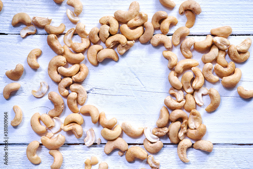 Cashew or caju nuts on white wooden background