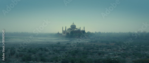 A view of Taj Mahal from the banks of Yamuna rivers with bluish mist and clam climate 