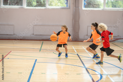 Kids in bright sportswear playing basketball together and feeling energized © zinkevych