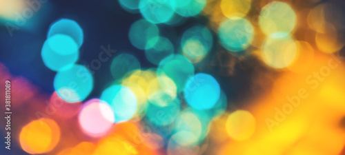Colorful background with natural bokeh texture and defocused sparkling lights. Teal and orange blur background with twinkling lights. Festive lights overlay or banner with copy space