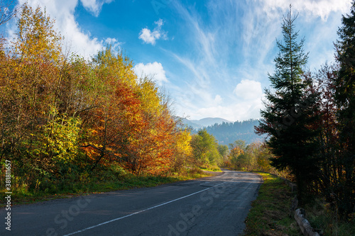 old asphalt road in mountains. beautiful autumn scenery on a sunny day. trees in colorful foliage. countryside journey on a weekend concept