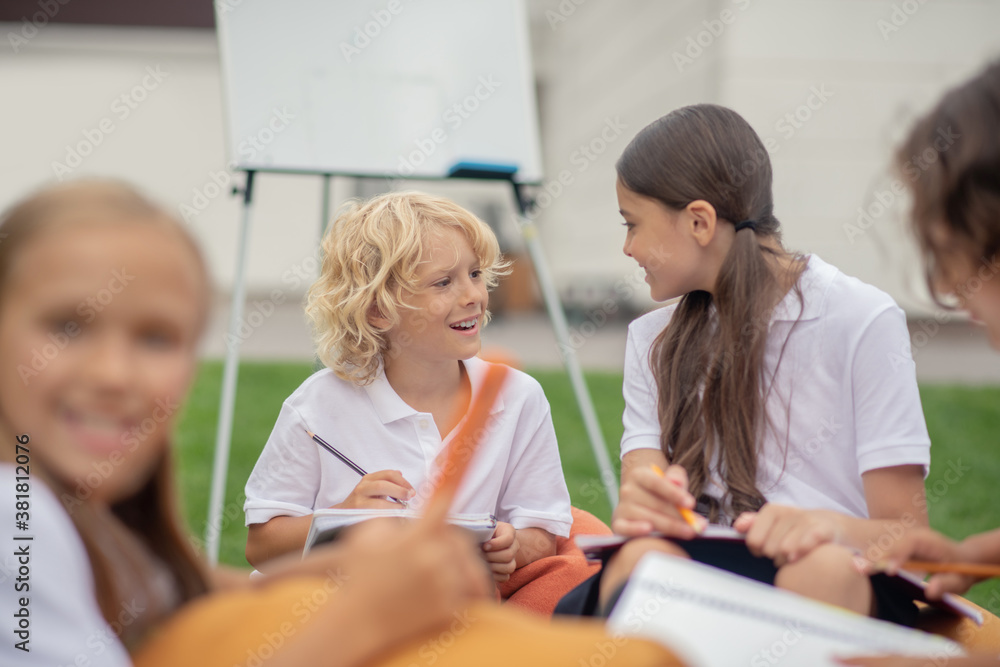 Children in white shirts sitting and talking Children in white shirts sitting and talking