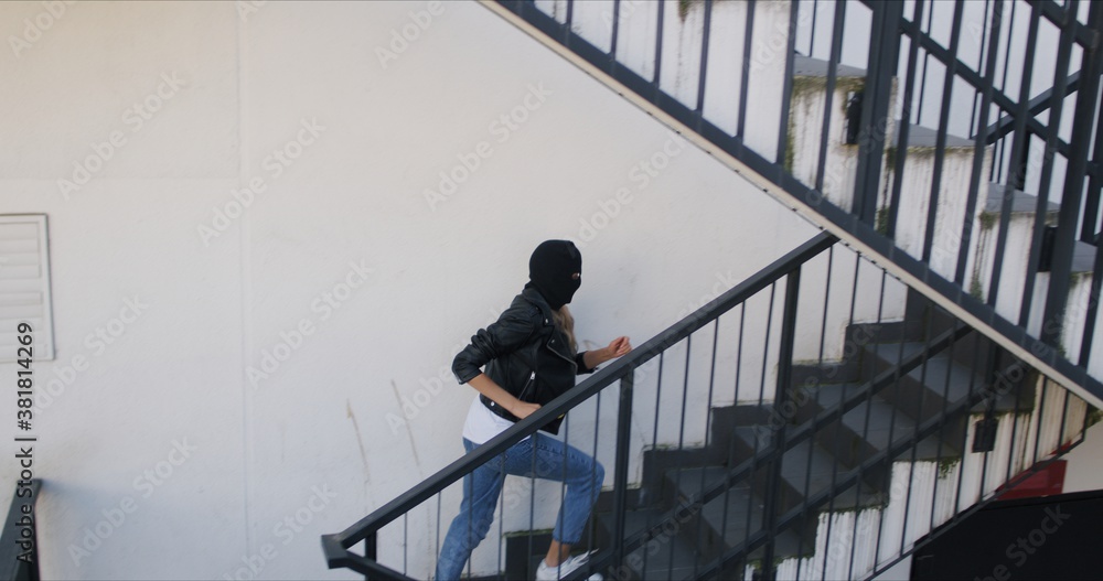 Woman wearing black balaclava and leather jacket Woman wearing black balaclava and leather jacket