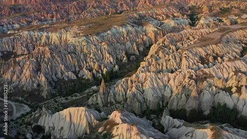 Cappadocia landscape with tuff stone formations after sunrise, tilt down aerial photo