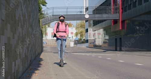 Fast food delivery courier rides electric scooter photo