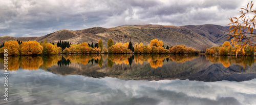 Autumn at Lake Ruataniwha, near Twizel, South Island, New Zealand - beautiful mirror reflection of autumn trees & mountain range photo