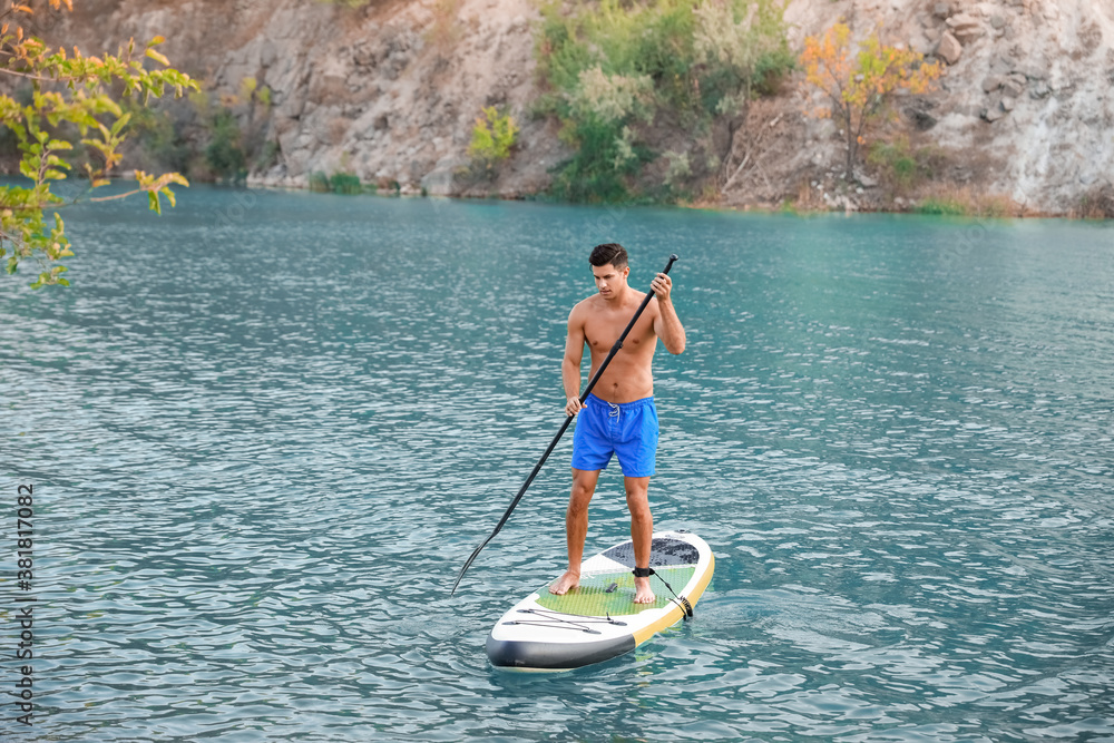 Young man using paddle board for sup surfing in river Young man using paddle board for sup surfing in river