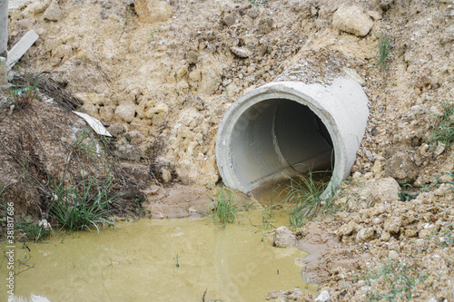 Embedding underground culvert for drainage and flood protection. Concrete sewer water drain pipe with drained water.