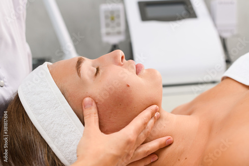 Beautician hands massage client face and chin