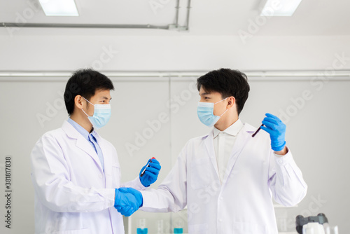 Successful and research working scientists man shake hands together in laboratory