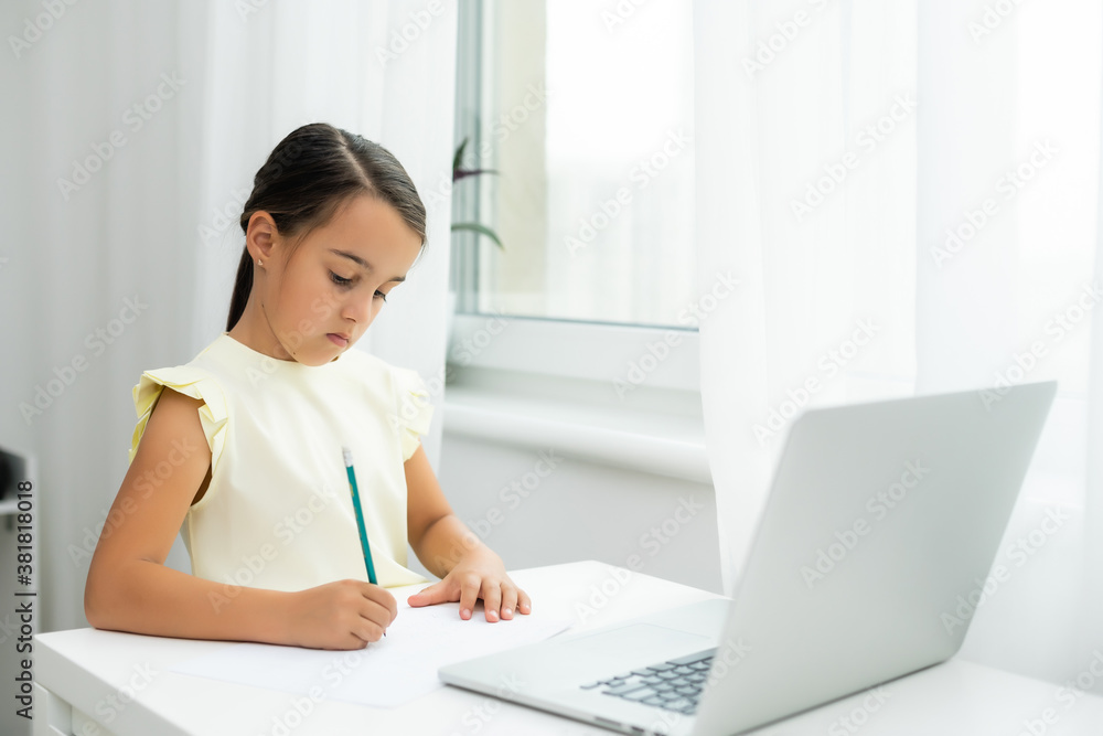 Litttle girl looking at laptop screen with expression of surprised and excitement. Smart, smilling little girl taking notes . Communication in business concept. Litttle girl looking at laptop screen with expression of surprised and excitement. Smart, smilling little girl taking notes . Communication in business concept.