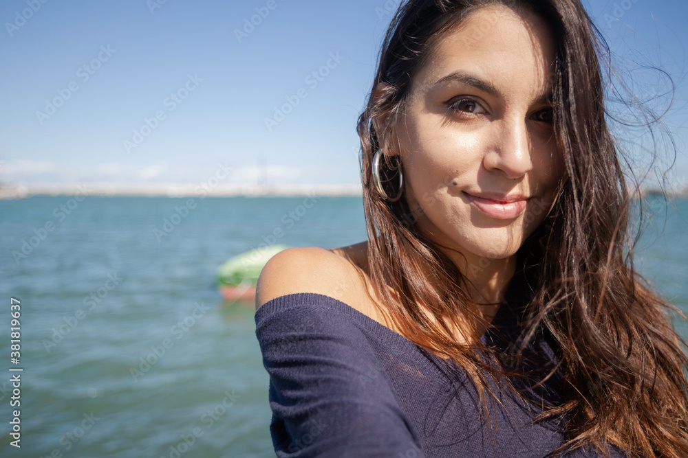 Close-up of a beautiful young italian woman with long dark hair as she looks into the camera