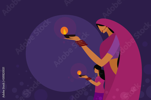 A mother and daughter wearing traditional dress holding Diwali oil lamps in their hands.Concept for Diwali festival in India