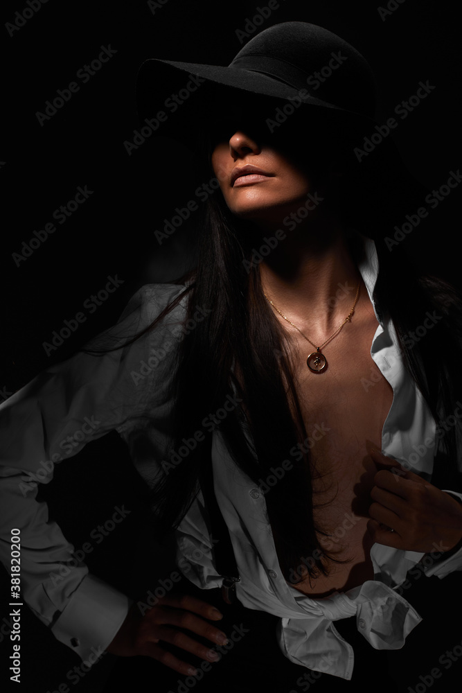 portrait of beautiful sexy brunette woman in white shirt and black hat on dark background portrait of beautiful sexy brunette woman in white shirt and black hat on dark background