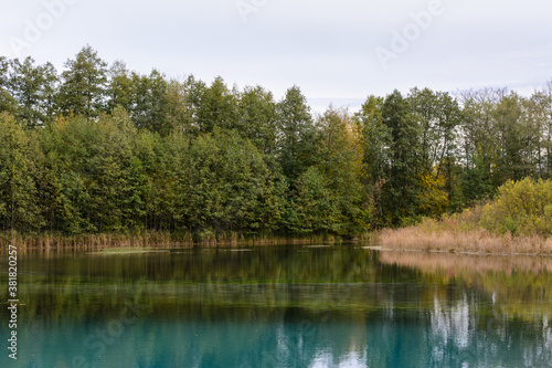 The reeds, grass, trees and turquoise water of a healing lake. Autumn landscape. Early autumn morning on the Blue Lake in Kazan.