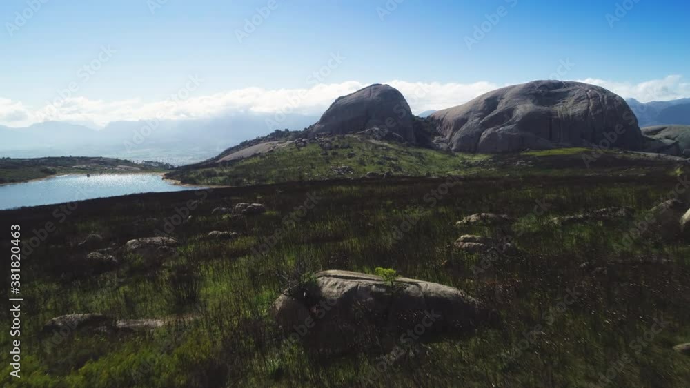 Aerial - Flying low over burnt fynbos, dam and granite monolith of Paarl Mountain in background Aerial - Flying low over burnt fynbos, dam and granite monolith of Paarl Mountain in background