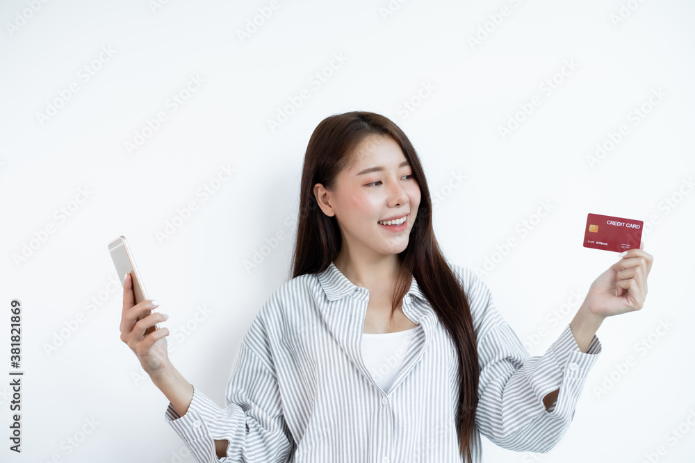 The Asian woman's hand is holding a credit card and using a smartphone for online shopping and internet payment in a happy way The Asian woman's hand is holding a credit card and using a smartphone for online shopping and internet payment in a happy way