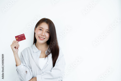 The hand of an Asian woman holding a credit card is used for online shopping and Internet payments