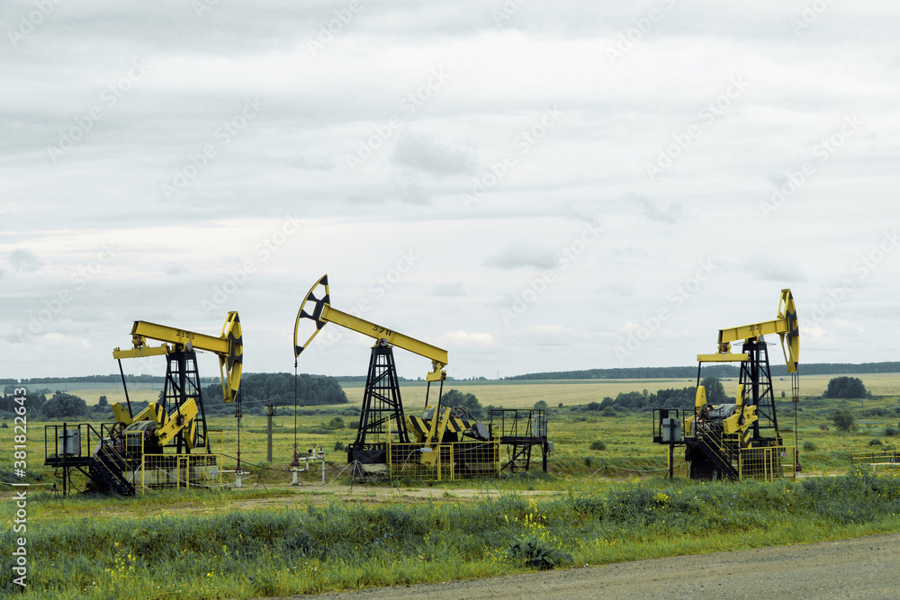 Oil and gas production equipment against cloudy sky Oil and gas production equipment against cloudy sky