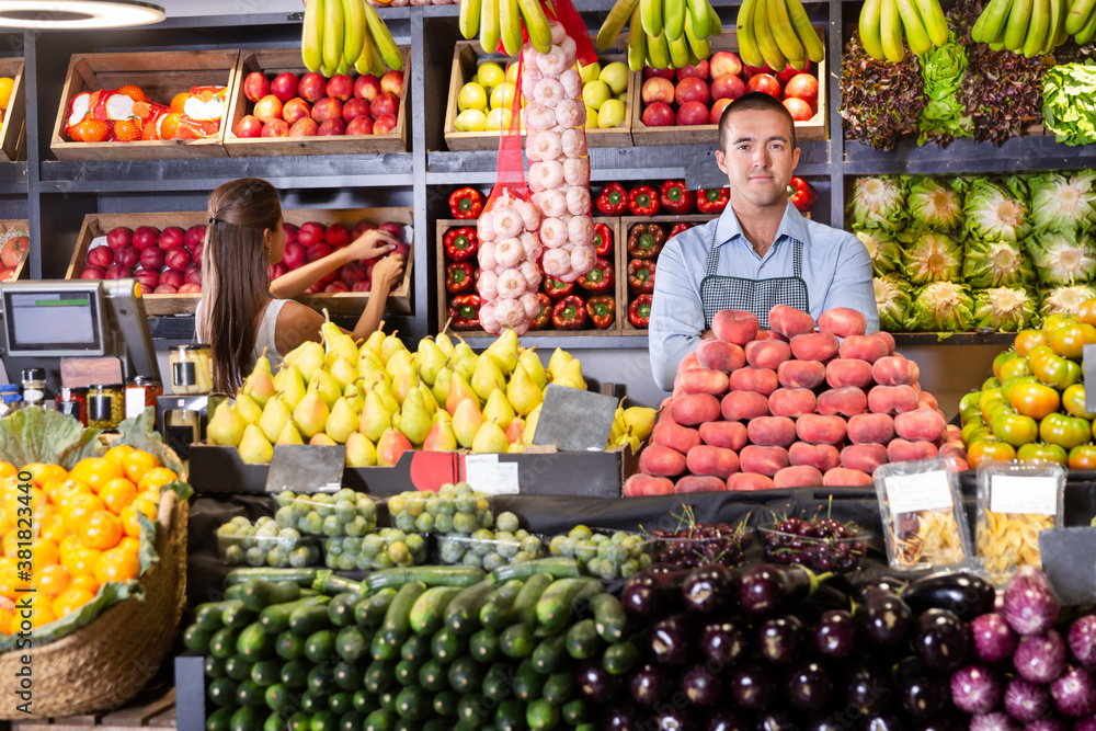 Portrait of male and female experienced shop assistants working in a fruit and vegetable shop